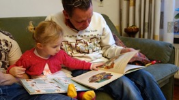 Father reading aloud to his daughter